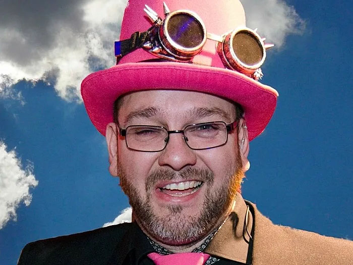 Dennis Fuller med lyserød hat, aftenens konferencier